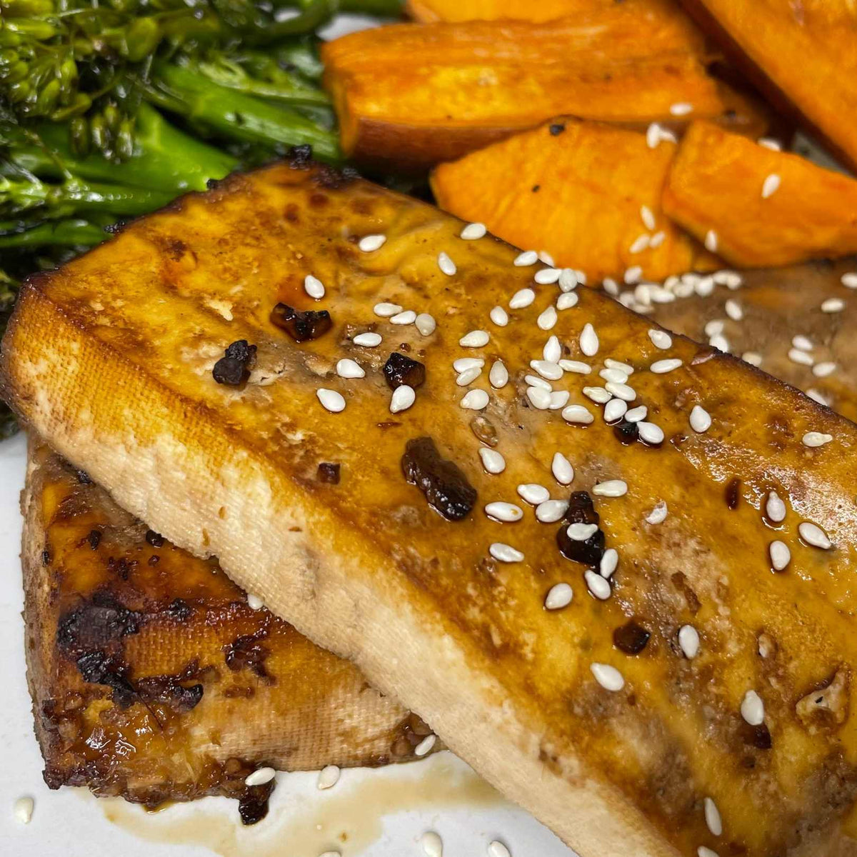 Teriyaki glaze'li tofu, susamlı broccolini ve tatlı patates kızartması